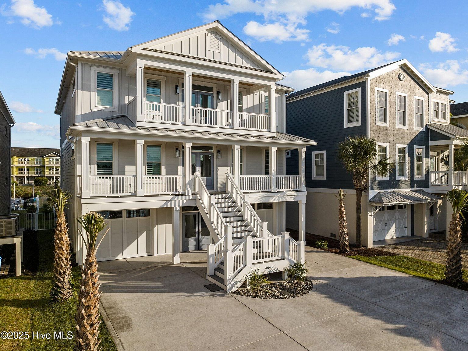4843 Williams Island Drive at golden hour , front elevation, white board-and-batten with metal roof, double-tier covered porches